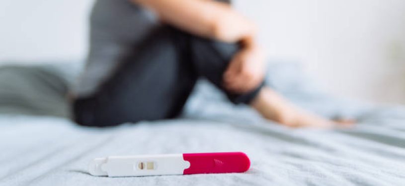 negative pregnancy test. sad woman on background